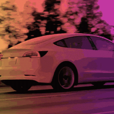 White Tesla Model 3 Driving Down Road GIF