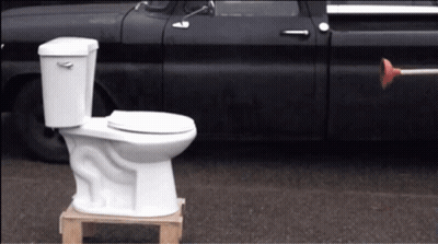 White Toilet On Wooden Pallet Next To Black Truck GIF