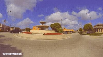 White Truck Driving Past Fountain City Of Hialeah GIF