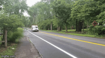 White Van Driving Down Road With Trees GIF