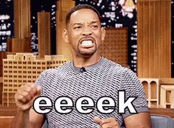 Will Smith Is Making A Funny Face While Sitting In Front Of A Microphone And Pointing At The Camera . GIF