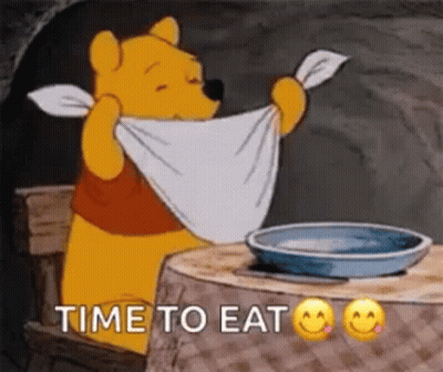 Winnie The Pooh Is Sitting At A Table Holding A Towel Around His Neck And Says `` Time To Eat '' . GIF