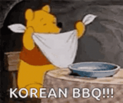 Winnie The Pooh Is Sitting At A Table Holding A Towel Over His Head And Saying `` Korean Bbq '' . GIF