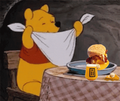 Winnie The Pooh Is Sitting At A Table With A Plate Of Food GIF