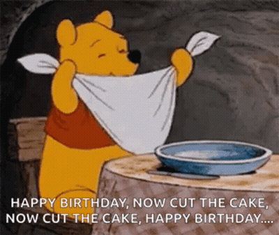 Winnie The Pooh Is Sitting At A Table With A Towel Around His Neck And A Plate Of Food . GIF