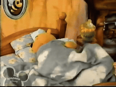 Winnie The Pooh Is Sleeping In A Bed With A Mickey Mouse Ear GIF