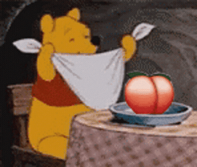 Winnie The Pooh Sitting At Table With Towel And Peach In Bowl GIF