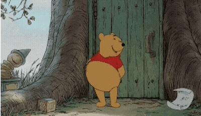Winnie The Pooh Standing In Front Of Wooden Door GIF