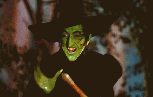 Witch With Green Face Paint And Black Hat GIF