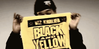 Wiz Khalifa Holding Black And Yellow Sign GIF