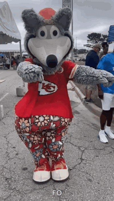 Wolf Mascot In Red Shirt And Floral Pants Standing On Street GIF