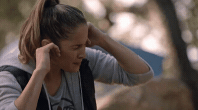 Woman Adjusting Ear Buds In Bear T-Shirt GIF