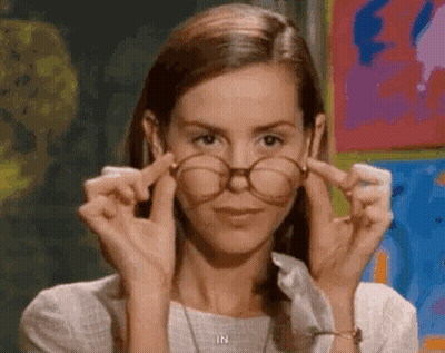 Woman Adjusting Glasses In Front Of Painting In Classroom GIF