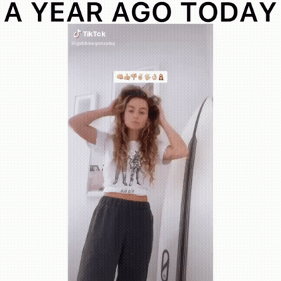 Woman Adjusting Hair Next To Surfboard A Year Ago Today GIF
