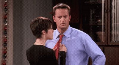 Woman Adjusting Man's Tie By Christmas Decoration GIF