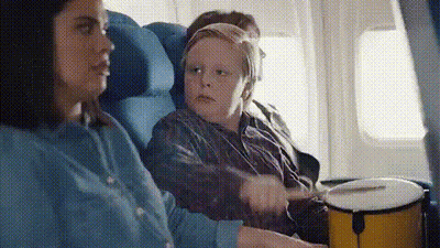 Woman And Boy Playing Drums On Airplane GIF