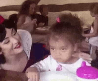 Woman and Little Girl Sitting at Table, Girl Drinking From Pink Cup