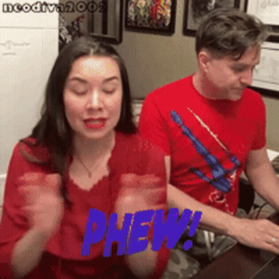 Woman And Man In Red Shirts Saying Phew GIF
