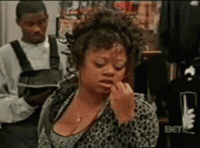 Woman Applying Lipstick In Store While Man Holds Book GIF