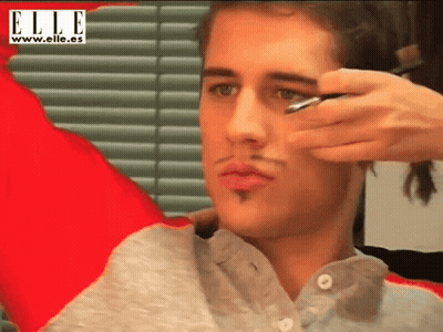 Woman Applying Makeup To Man Elle Banner GIF