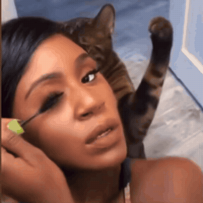 Woman Applying Mascara While Cat Watches GIF