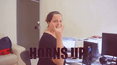 Woman At Computer With Horns Up On Screen GIF