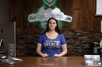 Woman At Desk In Front Of Mortgage Nerds Sign GIF