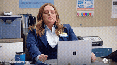 Woman At Desk With Laptop And Superstore Mug GIF