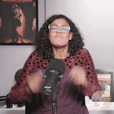 Woman At Microphone In Front Of Creepshow Poster GIF