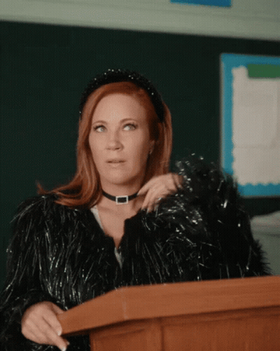 Woman At Podium In Choker And Fur Coat GIF