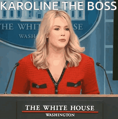 Woman At Podium With Karoline The Boss Sign GIF