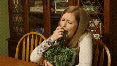 Woman At Table With Bowl Of Greens And Twister Game GIF