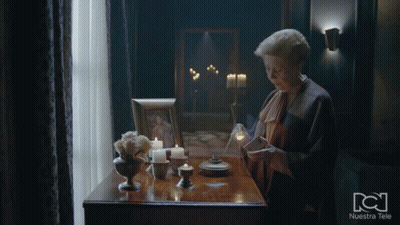 Woman At Table With Candles And Nuestra Tele Frame GIF