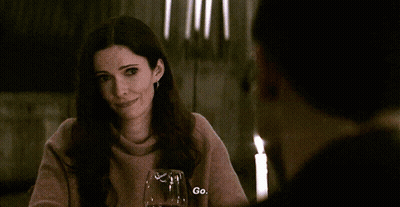 Woman At Table With Candles And Wine Says Go GIF