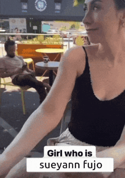Woman At Table With Caption Girl Who Is Sueyann Fujio GIF
