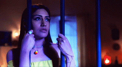 Woman Behind Bars With Rainbow Necklace GIF