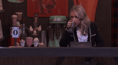 Woman Behind Counter With Sign Saying O GIF