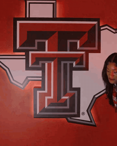 Woman Beside Large T On Red GIF