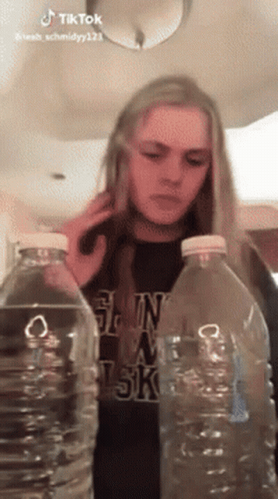 Woman Between Two Water Bottles Talking On Cell Phone GIF