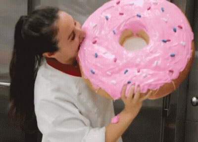Woman Biting Giant Pink Donut With Sprinkles GIF