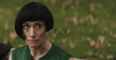 Woman Biting Nails In Front Of Trees GIF