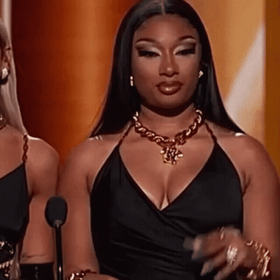 Woman Black Dress At Microphone With Gold Necklace GIF