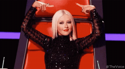 Woman Black Dress Pointing At Herself Red Chair GIF