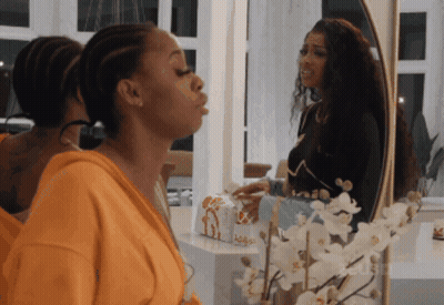 Woman Blowing Kiss In Front Of Mirror With Flowers GIF