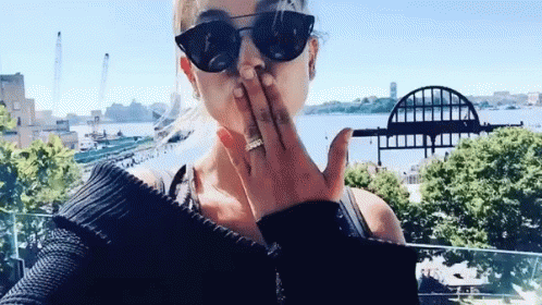 Woman Blowing Kiss In Front Of Water GIF