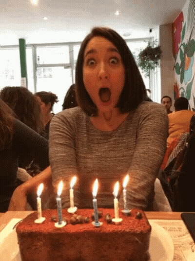 Woman Blowing Out Five Candles On Cake GIF