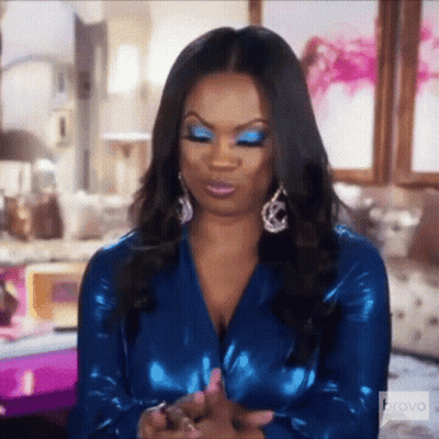 Woman Blue Dress Earrings Sitting On Bed GIF