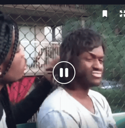 Woman Brushing Man's Hair In Front Of Chain Link Fence Playing Video GIF