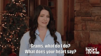 Woman By Christmas Tree Saying Grams What Does Your Heart Say GIF
