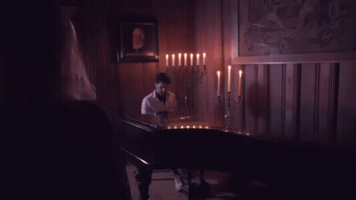 Woman By Man Playing Piano In Candlelit Room GIF